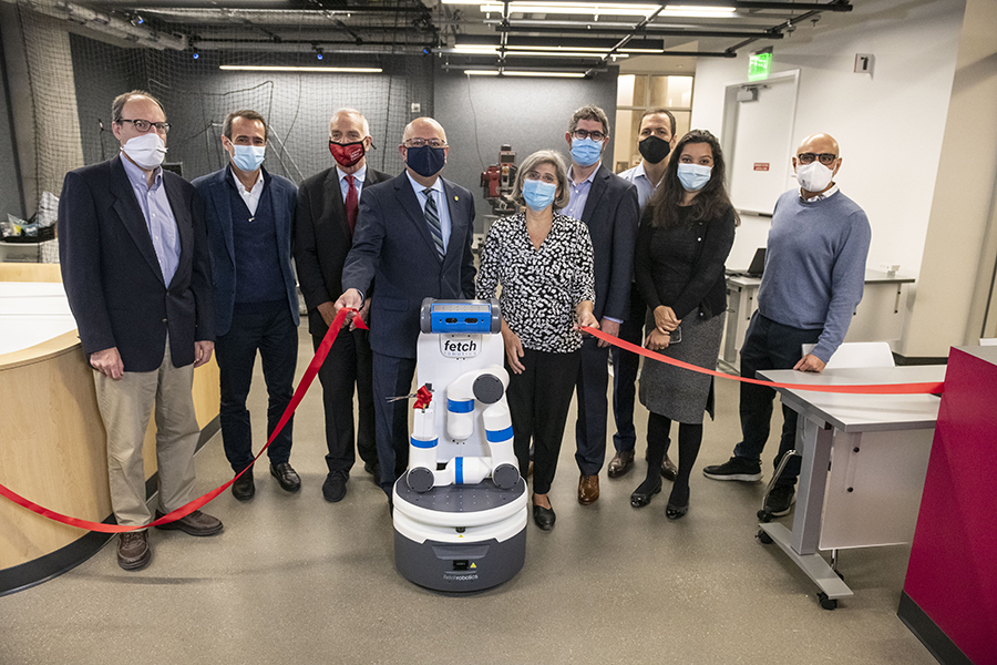  Leaders from CMU and JP Morgan pose with a robot that cut the ribbon at the space's opening.