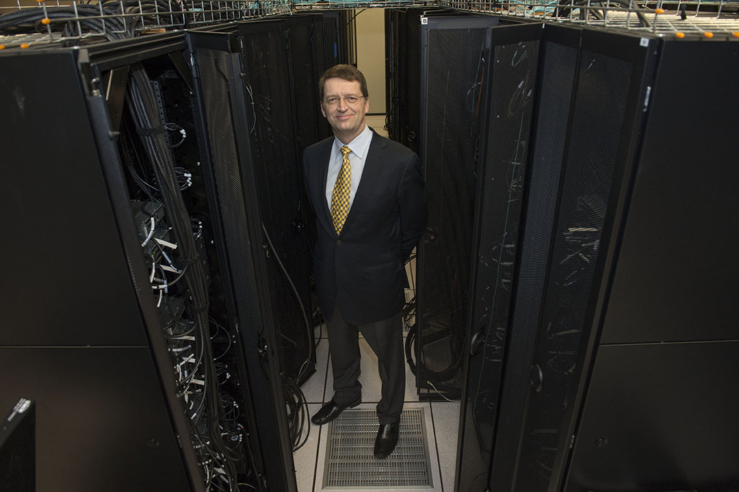  Tuomas Sandholm poses between banks of supercomputers.